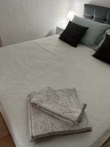 a white bed with two towels on top of it at Suite et Spa Les Abatilles in Arcachon