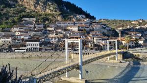 a bridge over a river with houses on a hill at Berat Private Appartment in Haxhialiu Villa in Berat