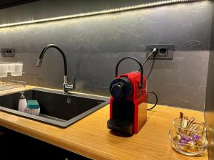 a red appliance sitting on a counter next to a sink at Chara's studio under Palamidi castle in Nafplio +19 photos