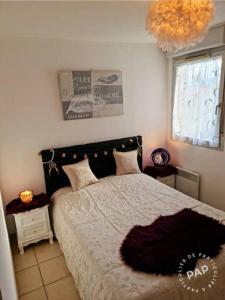 um quarto com uma cama e um lustre em Appartement cosy et lumineux à St Estève avec belle vue em Saint-Estève