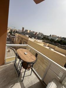 a table and chair on a balcony with a view at La Bella Guesthouse in St. Julianʼs