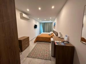 a bedroom with a bed and a desk in it at La Bella Guesthouse in St. Julianʼs