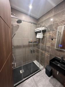 a bathroom with a shower with a glass door at La Bella Guesthouse in St. Julianʼs