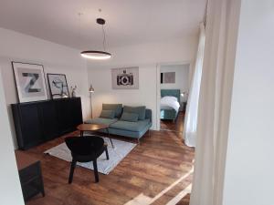 a living room with a blue couch and a table at Entrez Apartment Mlynská Bašta – Košice old center in Košice