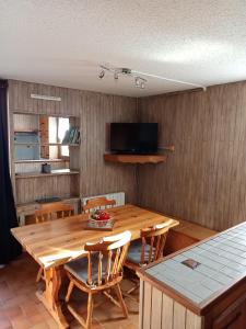 Appartement saisonnier Orcières Merlette في أورسيير: غرفة طعام مع طاولة وكراسي خشبية