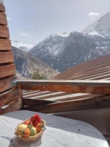 a basket of fruit sitting on a table with a mountain at Appartement saisonnier Orcières Merlette in Orcières