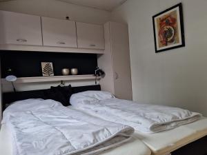 a bedroom with two white sheets on a bed at Kustverhuur, Groede, Paarlhof 17 in Groede