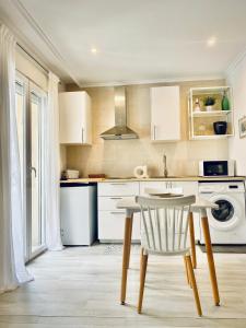 cocina con mesa y fregadero en Casa La Ola Azul, en Alicante