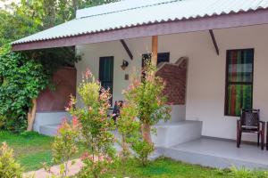 a small white house with a porch and a chair at Beacon villa in Anuradhapura