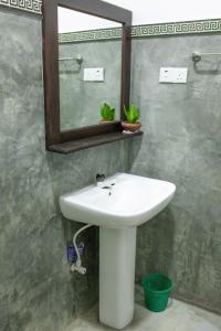 a bathroom with a white sink and a mirror at Beacon villa in Anuradhapura