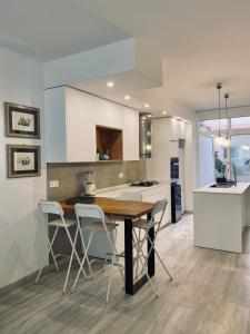Una cocina con una mesa y sillas de madera. en Casa La Ola Azul, en Alicante
