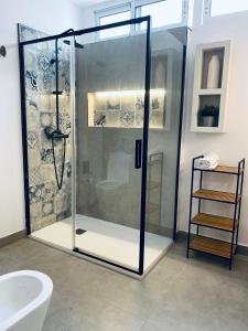 Un baño con ducha con puerta de cristal. en Casa La Ola Azul, en Alicante