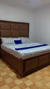 a bed with a wooden frame and blue pillows on it at Blue Moon Hotel Victoria Island in Lagos