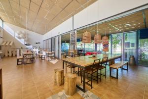 HolaCamp Vall Natura في Sant Miquel de Campmajor: غرفة طعام مع طاولة وكراسي خشبية كبيرة