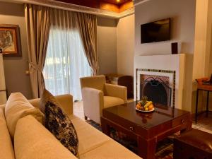 een woonkamer met een bank en een open haard bij Pavillon du Golf -Palmeraie suites in Marrakesh