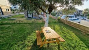 a wooden bench sitting next to a tree at Villa Begonvil in Kusadası +28 photos