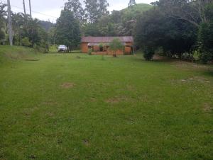 een tuin met een huis en een groen veld bij Camping Casa Velha in Guarapari