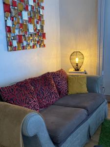 un sofá en una sala de estar con lámpara en Gîte d'Avalon Appartement 5, en Dinant
