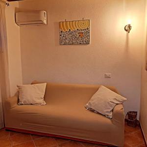 a couch sitting in a room with two pillows at Villa Maria Citara Beach in Forio d'Ischia