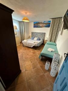 um quarto com uma cama e uma cadeira em Villa Maria Citara Beach em Ischia