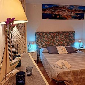 um quarto com uma cama e uma mesa com um candeeiro em Villa Maria Citara Beach em Ischia