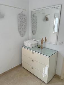 ein Badezimmer mit einer Kommode und einem Spiegel in der Unterkunft House Isleta Dream in Las Palmas de Gran Canaria