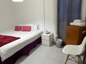 a bedroom with a bed and a chair and a window at Habitación por días in Catarroja
