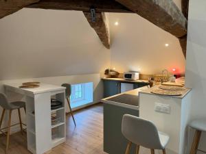 a kitchen with a counter and a table and chairs at Logement cocon in Chaudenay