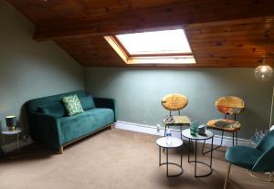 Suite Emeraude في Prémilhat: غرفة معيشة مع أريكة وكراسي خضراء