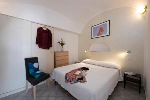 una camera d'albergo con una donna seduta su un letto di Sol Levante ad Amalfi