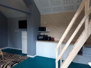 Zimmer mit einer Küche mit einer Treppe und einer Mikrowelle in der Unterkunft Apartement à Theuville-Baigneaux in Theuville