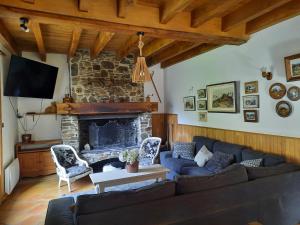 uma sala de estar com um sofá e uma lareira em La Grange Des Biches em Benque-Dessous-et-Dessus