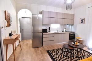 a kitchen with a stainless steel refrigerator and a table at Antoine Apartment in Nea Peramos