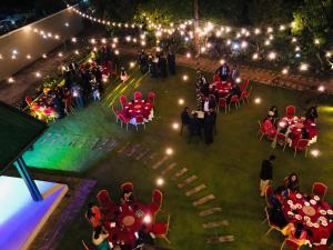 een uitzicht op een feest met tafels en stoelen in de nacht bij Serenemo Eco Resort in Pundaluoya