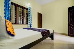 1 dormitorio con 1 cama en una habitación con ventana en SPOT ON Riyan Suites, en Ernakulam