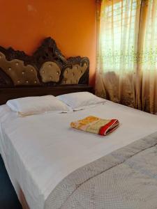 a large white bed with a wooden headboard and curtains at Hotel Short Time Stay in Dhaka