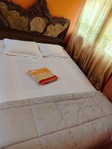 a white bed with a red towel on it at Hotel Short Time Stay in Dhaka