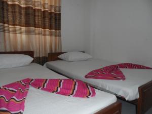 2 Betten nebeneinander in einem Zimmer in der Unterkunft D2 Holiday Inn in Badulla