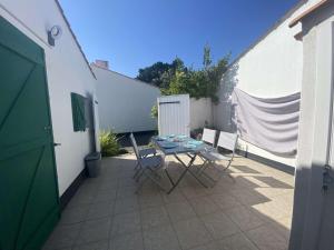 a patio with a table and chairs next to a building at FERME MARINE T2 in Bretignolles-sur-Mer