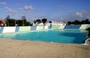 a large swimming pool with blue water at FERME MARINE T2 in Bretignolles-sur-Mer