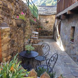 un patio al aire libre con mesas, sillas y plantas en Apartamentos rurales Casa Xepo, en Rengos