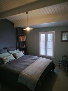 Un dormitorio con una cama grande y una ventana. en Chambre d'hôte ensoleillée à 300m de la plage, en La Guérinière