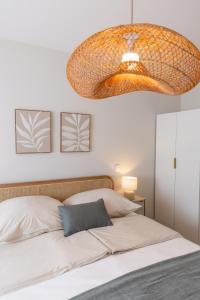 ヴィラ・ド・コンデにあるBlue House- am Strand von Vila do Conde, Portoのベッドルーム1室(大きなシャンデリア付きのベッド1台付)