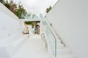una escalera en un edificio blanco con barandilla de cristal en Villa glamur en Les Botigues de Sitges 