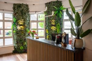 a lobby with a green wall with plants at Kontaktlos Hotel Vintage in Pulheim