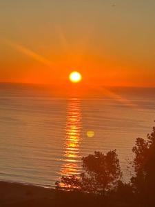 una puesta de sol sobre el océano con el sol reflejándose en el agua en Villa glamur en Les Botigues de Sitges 