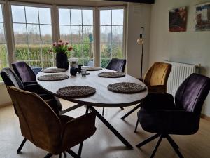a table and chairs in a room with a large window at Kustverhuur, Groede, Paarlhof 17 in Groede