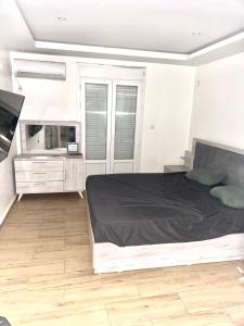 a bedroom with a large bed and a television at Appartement Luxe F4 Bordj El kiffan in Fort de lʼEau