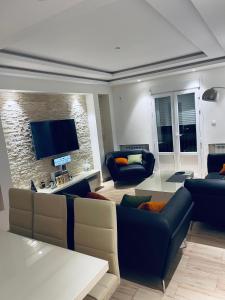 a living room with couches and a flat screen tv at Appartement Luxe F4 Bordj El kiffan in Fort de lʼEau