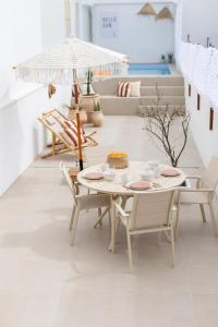 a white room with a table and chairs and an umbrella at Blue House- am Strand von Vila do Conde, Porto in Vila do Conde